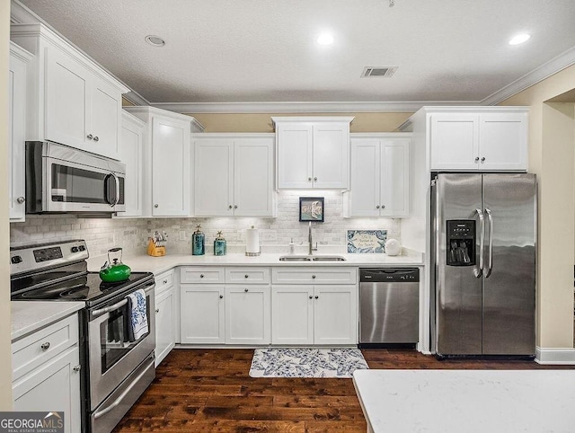 kitchen with white cabinetry, sink, dark hardwood / wood-style flooring, appliances with stainless steel finishes, and ornamental molding