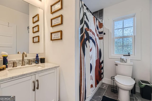 bathroom featuring vanity, toilet, and a wealth of natural light