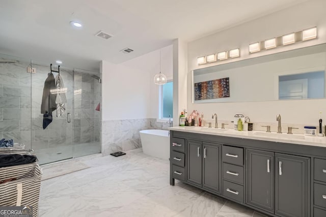 bathroom featuring vanity and independent shower and bath