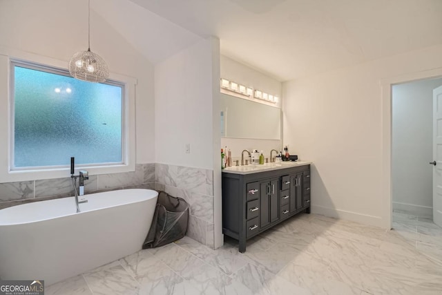 bathroom featuring a wealth of natural light, vanity, a bathtub, and tile walls