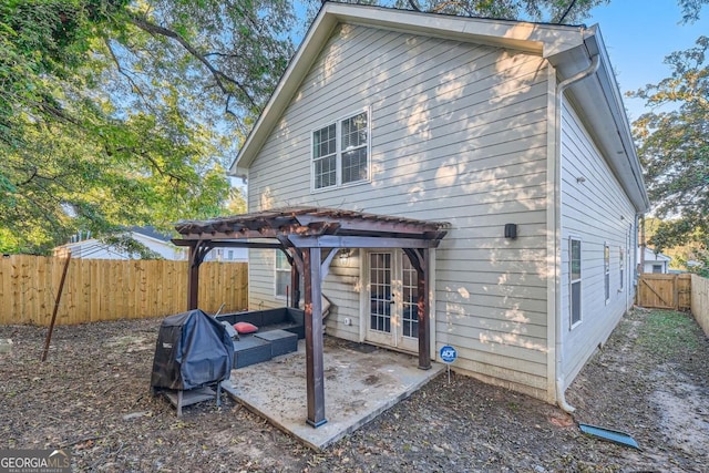 rear view of property with a patio area, a pergola, and french doors