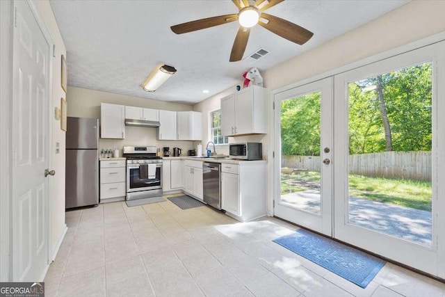 kitchen with french doors, stainless steel appliances, ceiling fan, sink, and white cabinets