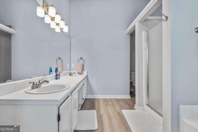 bathroom featuring hardwood / wood-style floors, vanity, and walk in shower