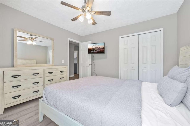 bedroom with ceiling fan, a closet, a textured ceiling, and light wood-type flooring