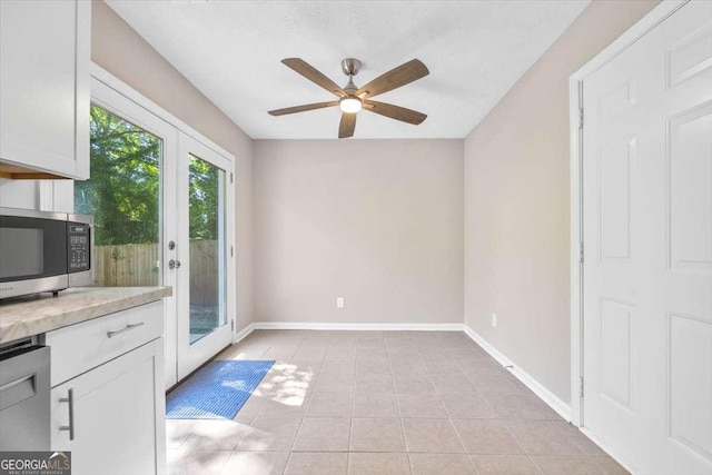 interior space with ceiling fan and light tile patterned floors