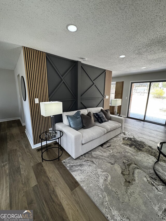 unfurnished living room with a textured ceiling, a fireplace, dark hardwood / wood-style floors, and ceiling fan