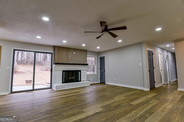 unfurnished living room featuring ceiling fan, a fireplace, and light hardwood / wood-style flooring