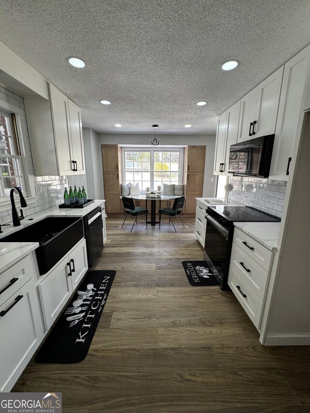 kitchen with electric stove, hanging light fixtures, and white cabinetry