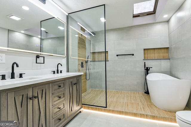 full bathroom with vanity, toilet, separate shower and tub, and tile walls