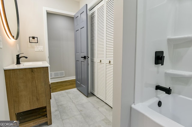 bathroom with washtub / shower combination and vanity