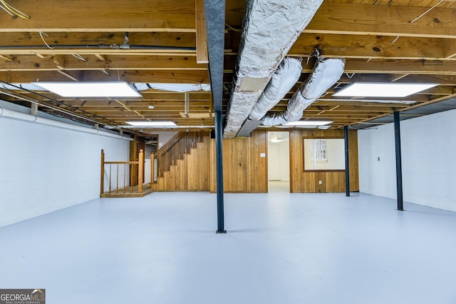 basement featuring wood walls