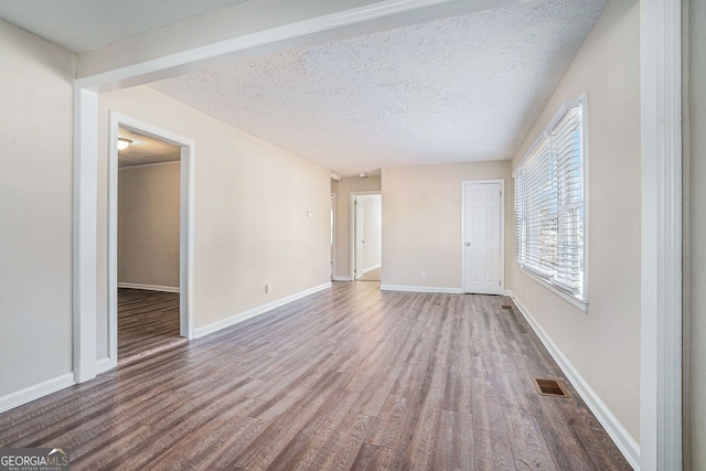 unfurnished room with wood-type flooring and a textured ceiling