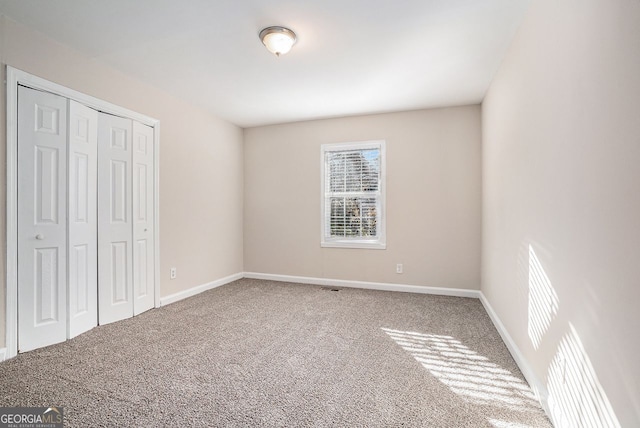 unfurnished bedroom featuring carpet and a closet