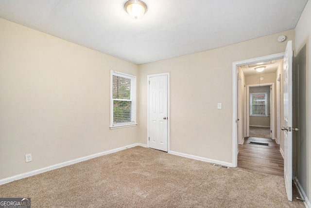 unfurnished bedroom featuring a closet, carpet floors, and multiple windows