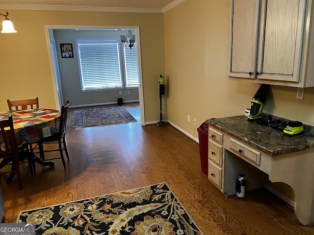 kitchen featuring crown molding, pendant lighting, dark stone counters, and dark hardwood / wood-style floors