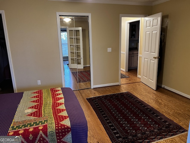 unfurnished bedroom with hardwood / wood-style flooring, ornamental molding, and a closet