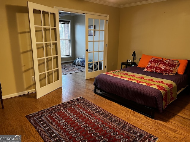 bedroom featuring wood-type flooring, ornamental molding, and french doors