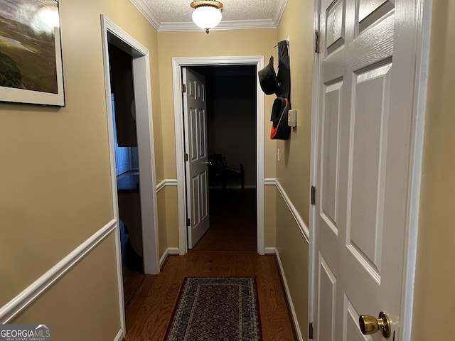 hallway with crown molding, dark hardwood / wood-style flooring, and a textured ceiling