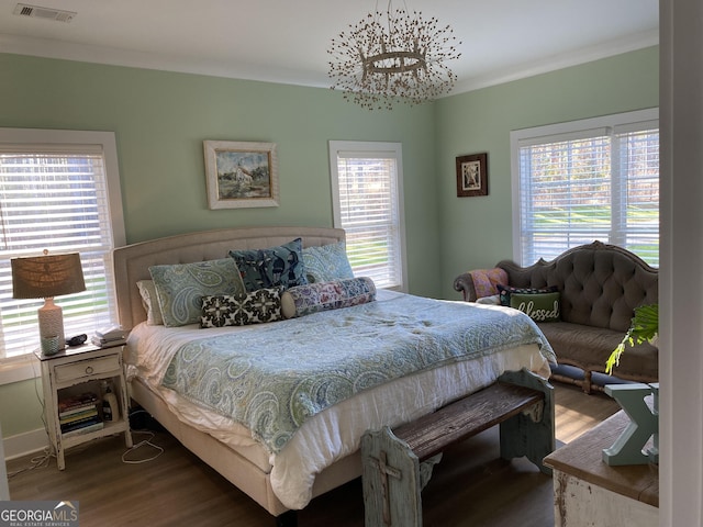 bedroom featuring a notable chandelier, wood-type flooring, and crown molding