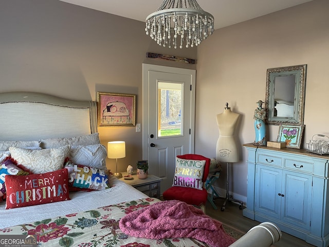 bedroom with dark hardwood / wood-style flooring and a notable chandelier