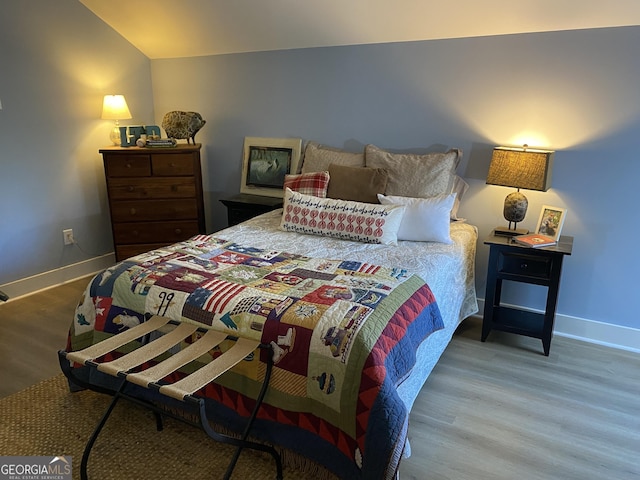 bedroom featuring vaulted ceiling and hardwood / wood-style flooring