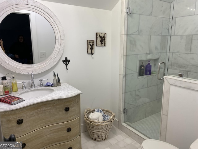 bathroom with tile patterned flooring, vanity, toilet, and a shower with shower door