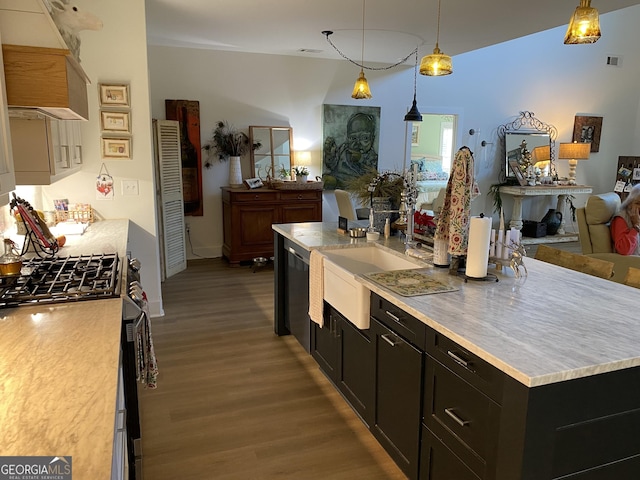 kitchen featuring gas stove, a center island, sink, dark hardwood / wood-style floors, and pendant lighting