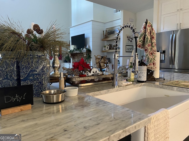 kitchen featuring white cabinetry, stainless steel fridge with ice dispenser, and sink