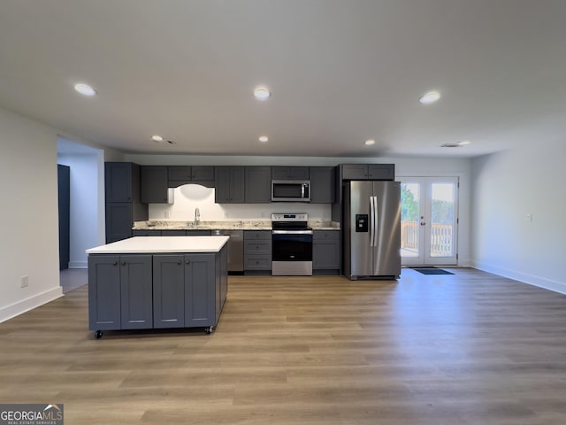 kitchen featuring stainless steel appliances, light hardwood / wood-style flooring, gray cabinetry, and sink