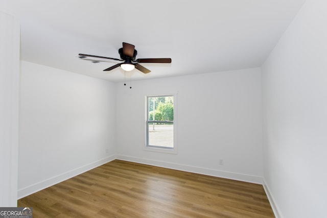 empty room with ceiling fan and hardwood / wood-style flooring