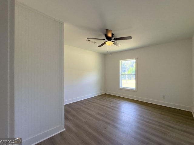 spare room with dark hardwood / wood-style flooring and ceiling fan