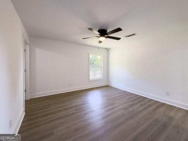 unfurnished room with ceiling fan and dark wood-type flooring