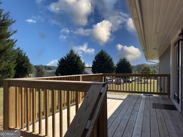 wooden terrace featuring a yard