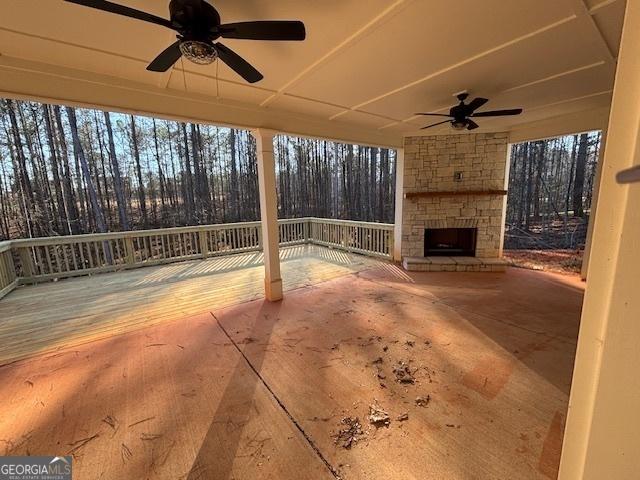 view of patio featuring an outdoor stone fireplace and ceiling fan