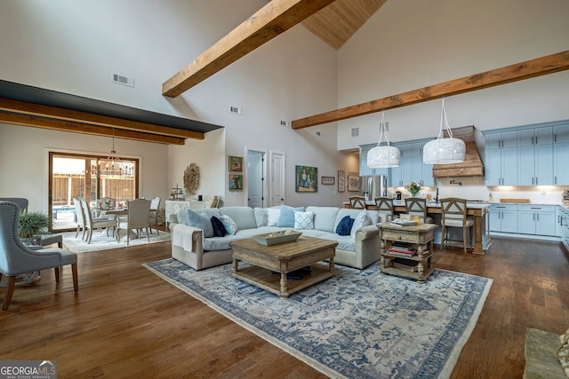 living room with dark hardwood / wood-style floors, high vaulted ceiling, and a notable chandelier