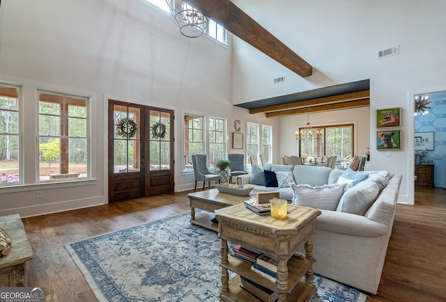 living room with dark hardwood / wood-style flooring, french doors, beamed ceiling, and a notable chandelier