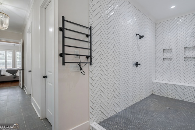 bathroom with a tile shower, tile patterned floors, an inviting chandelier, and ornamental molding