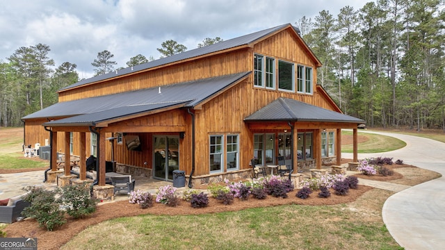 back of house with a patio area and a lawn