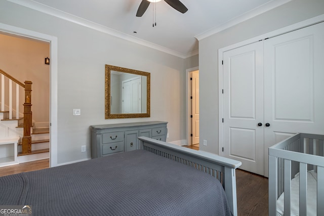 unfurnished bedroom featuring ceiling fan, dark hardwood / wood-style floors, a closet, a crib, and ornamental molding