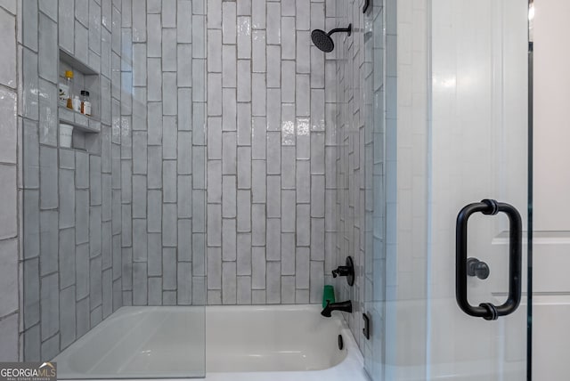 bathroom with bath / shower combo with glass door