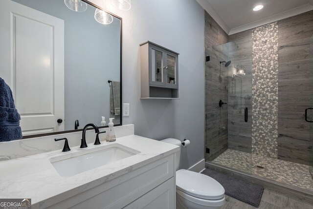 bathroom with vanity, a shower with shower door, and toilet
