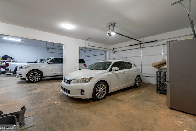 garage with a garage door opener and stainless steel refrigerator