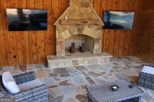 living room featuring wood walls and a fireplace