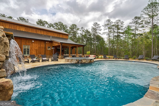 view of swimming pool featuring an in ground hot tub, pool water feature, and a patio