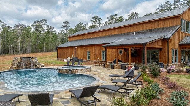 view of pool with an in ground hot tub, pool water feature, and a patio