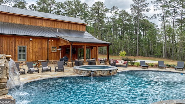 view of swimming pool featuring pool water feature, a patio area, an outdoor hangout area, and an in ground hot tub