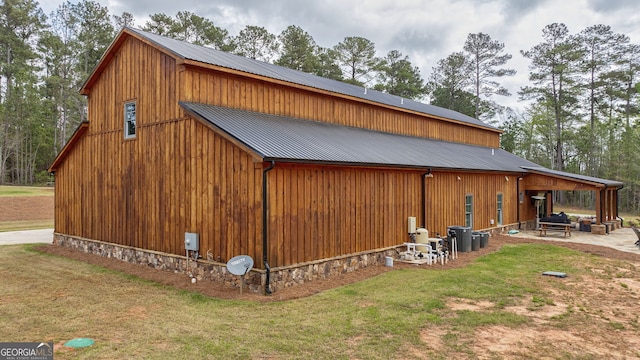 view of side of home with a patio area and a lawn