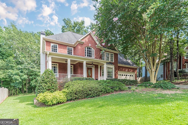 view of front facade featuring a garage, covered porch, and a front lawn