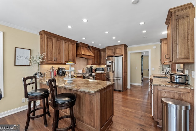 kitchen with premium range hood, kitchen peninsula, stainless steel appliances, crown molding, and light stone counters