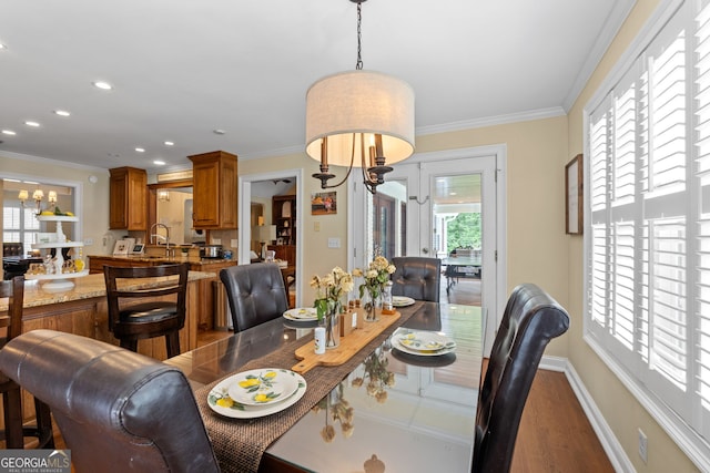 dining room featuring hardwood / wood-style flooring, sink, and ornamental molding